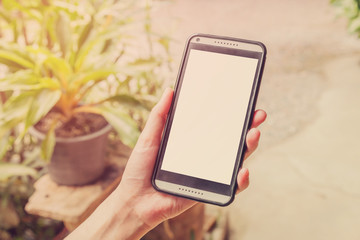 Hand holding mobile phone with vintage effect.