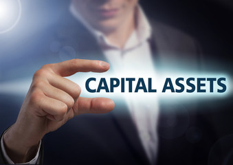Businessman presses button capital assets on virtual screens. Bu