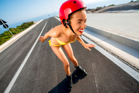 Woman in swimsuit with rollers on the highway
