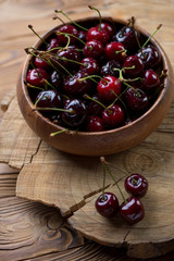 Wooden bowl with fresh sweet cherries, studio shot, close-up
