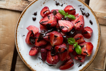 Strawberry covered with chocolate on a plate, above view