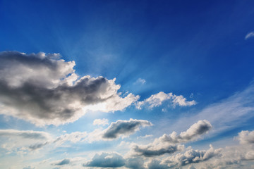 Blue cloudy sky with sun rays