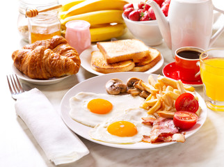 Breakfast  with fried eggs, coffee, orange juice, toasts and fru