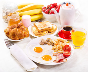 Breakfast  with fried eggs, coffee, orange juice, toasts and fru