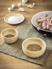 ingredient in bowl and raw chicken on wooden table