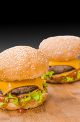 Two tasty cheeseburgers with lettuce; beef; double cheese and ketchup. Shallow focus.