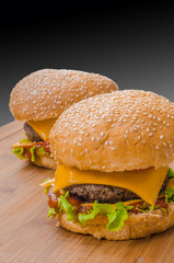Two tasty cheeseburgers with lettuce; beef; double cheese and ketchup. Shallow focus.