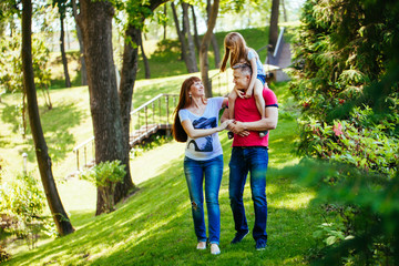 Fototapeta premium A young family, a pregnant mother, father, daughter