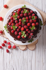 Chocolate cake with raspberries and mint on the table vertical top view
