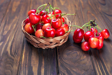 Ripe cherries on wooden table in a basket