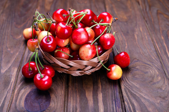 Ripe cherries on wooden table in a basket