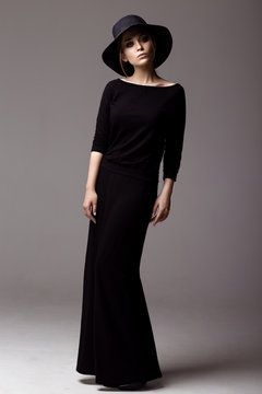 Full Length Shot Of A Woman In Long Black Dress And Hat