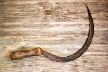 sickle on wooden background