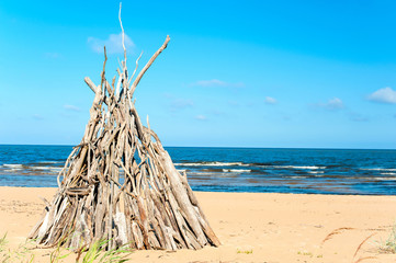 Wigwam Made from wooden branches on the sand of baltic sea beach