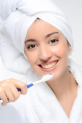 face close-up of a beautiful young brunette ethnic woman brushing her teeth