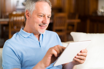 Smiling mature man using a digital tablet