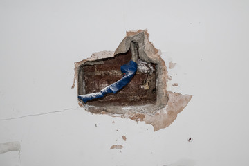 cavity in interior wall showing electrical wires covered in insulating tape
