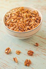 Walnut Kernels in Bowl on Rustic Wooden Background