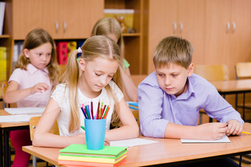 Schoolboy cheating at exam, looking at a friend's writing