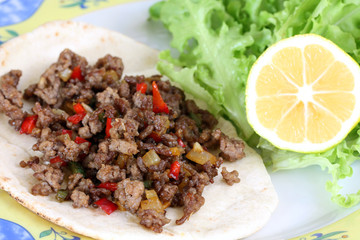 healthy eating: grilled beef taco with vegetables, salad and lemon served on plate
