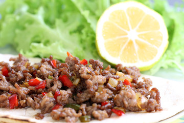 healthy eating: grilled beef taco with vegetables, salad and lemon served on plate
