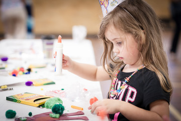 little girl making handcraft at a table