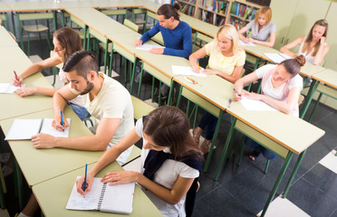 Students writing dictation in classroom