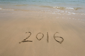 Year 2016 written in sand, on tropical beach