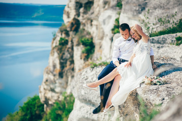 Fototapeta premium beautiful young couple posing on the rock near the lake