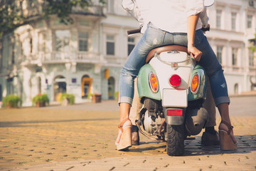 Back view portrait of a scooter with female legs in old european town © Drobot Dean