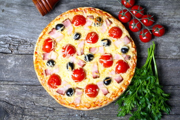 pizza with bacon, olives and tomato