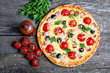 pizza with bacon, olives and tomato