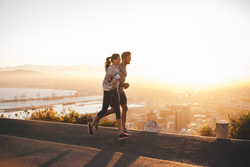 Young couple jogging on hillside road