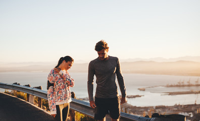 Young couple taking a break from running session