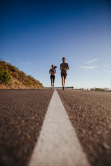 Obraz premium Two young people jogging on the road