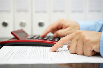 businessman is reading financial document and calculating result