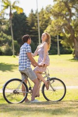Fototapeta na wymiar Young couple on a bike ride in the park