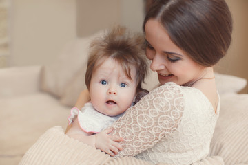 Portrait of happy mother with baby,posing lying on the bed
