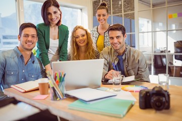 Portrait of smiling casual colleagues using computer