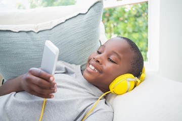 Little boy listening to music on the couch
