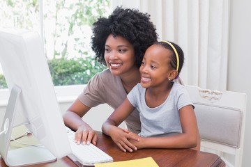 Happy mother and daughter using the computer