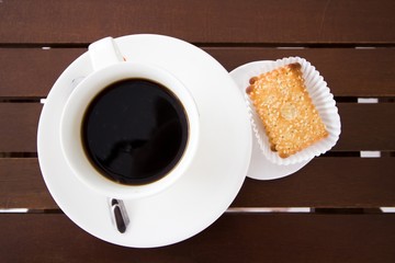 A cup of coffee with sesame biscuits