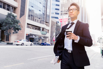 Businessman with coffee in a city
