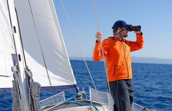 Man sailing with sails out on a sunny day