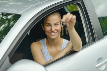 Obraz na płótnie Canvas Smiling Young Woman in her Car Holding Keys