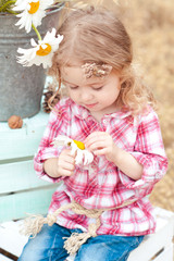 Cute kid girl 2-3 year old holding flower outdoors. Childhood. 