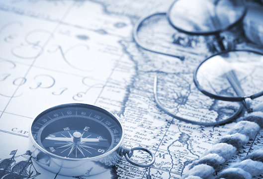 Compass and glasses on vintage map