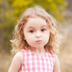 Baby girl 2-3 year old looking at camera over nature background outdoors. Childhood. 