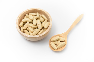 Alternative medicine tablets on a wooden spoon