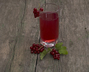 glass of juice and red currant on the old desktop